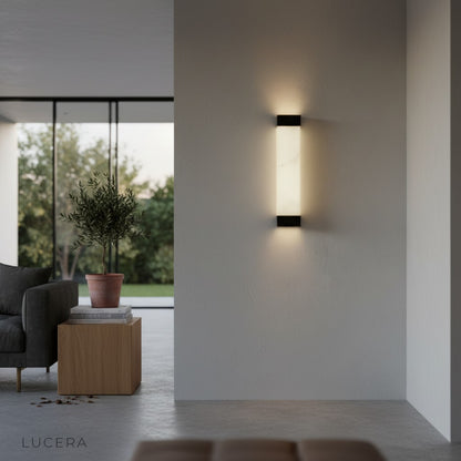 Marco wall fixture in elegant entryway with marble panel and copper details