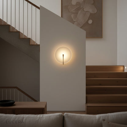 sculptural white marble wall light above study desk with books