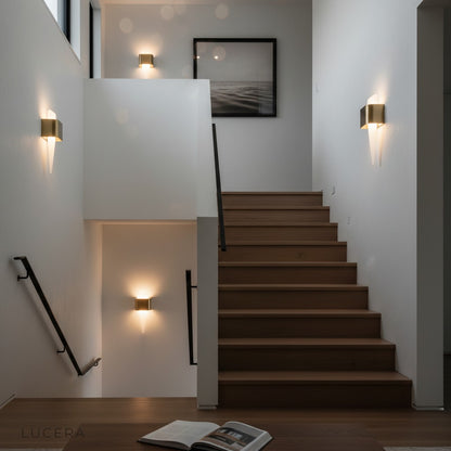 Passo Shark Tooth lamp illuminating a modern hallway with warm accent lighting at dusk