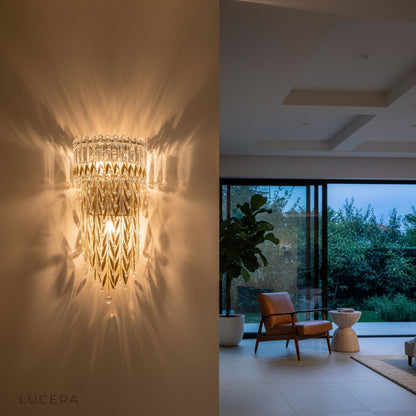 Sera golden crystal wall lamp illuminated at night in cozy bedroom setting