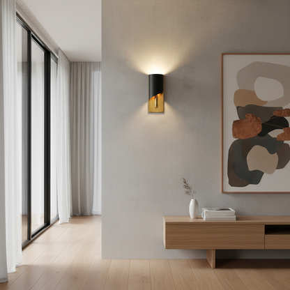 Duomo copper wall light with warm glow beside a leather armchair in a rustic lounge