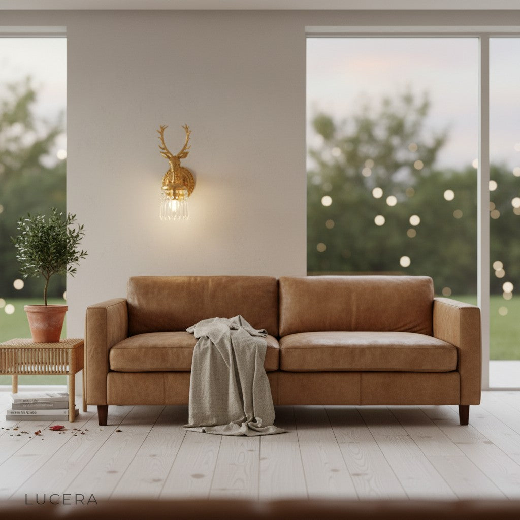 nighttime lifestyle shot of Capri deer head wall lamp glowing softly above a velvet armchair