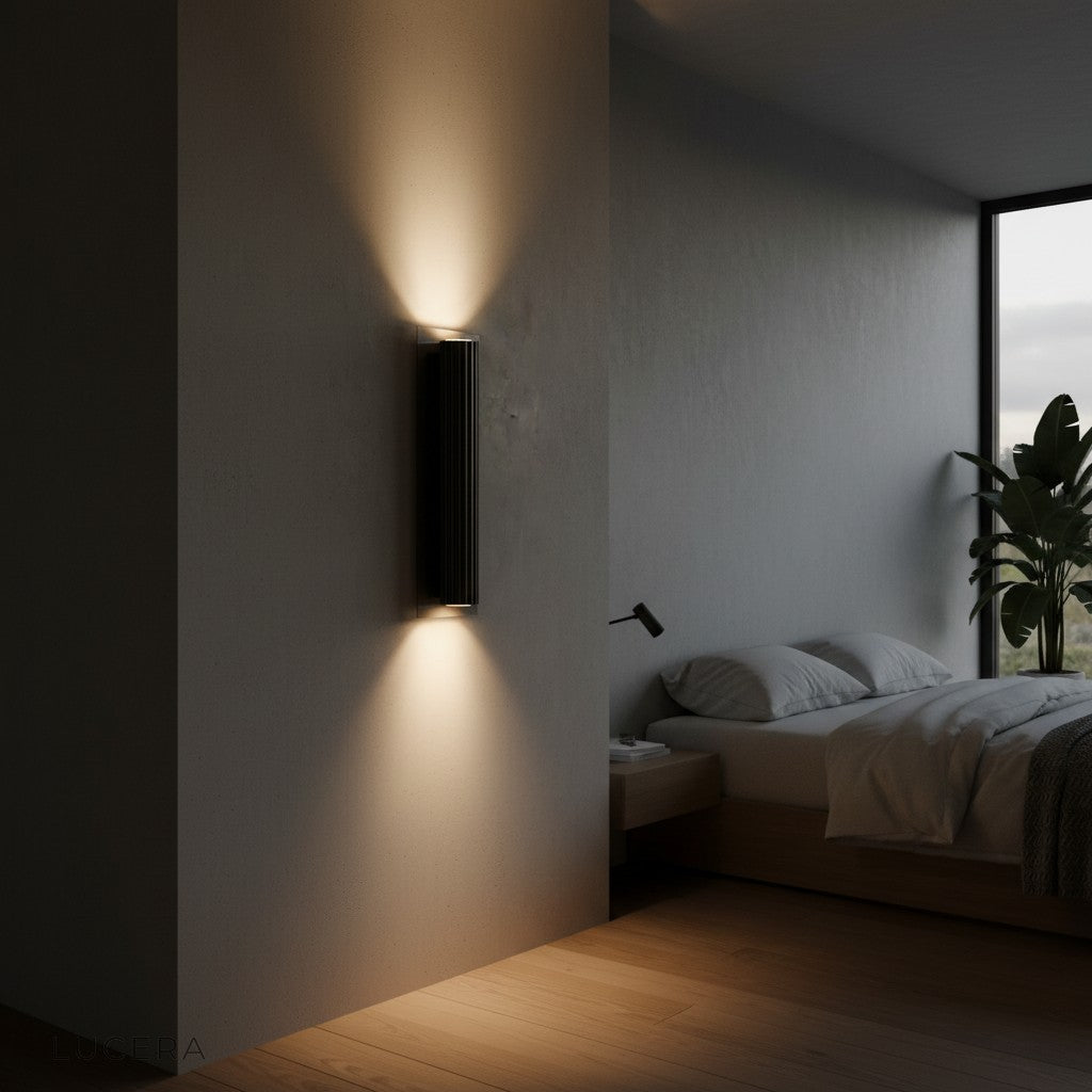 Loano classic wall lamp glowing softly above sofa in elegant evening living room