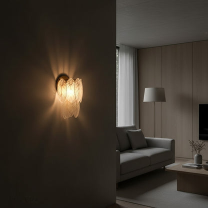 Albenga feather wall lamp lit at night beside cozy armchair and bookshelf
