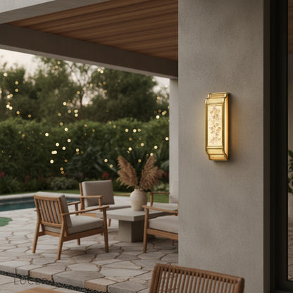 Bordure wall lamp lit at night casting soft shadows on textured interior wall
