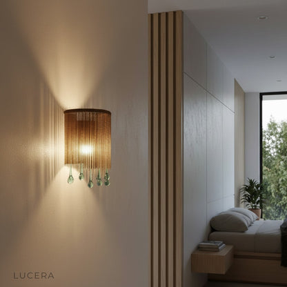 ambient nighttime shot of Mesure crystal sconce casting sparkling glow on bedroom wall