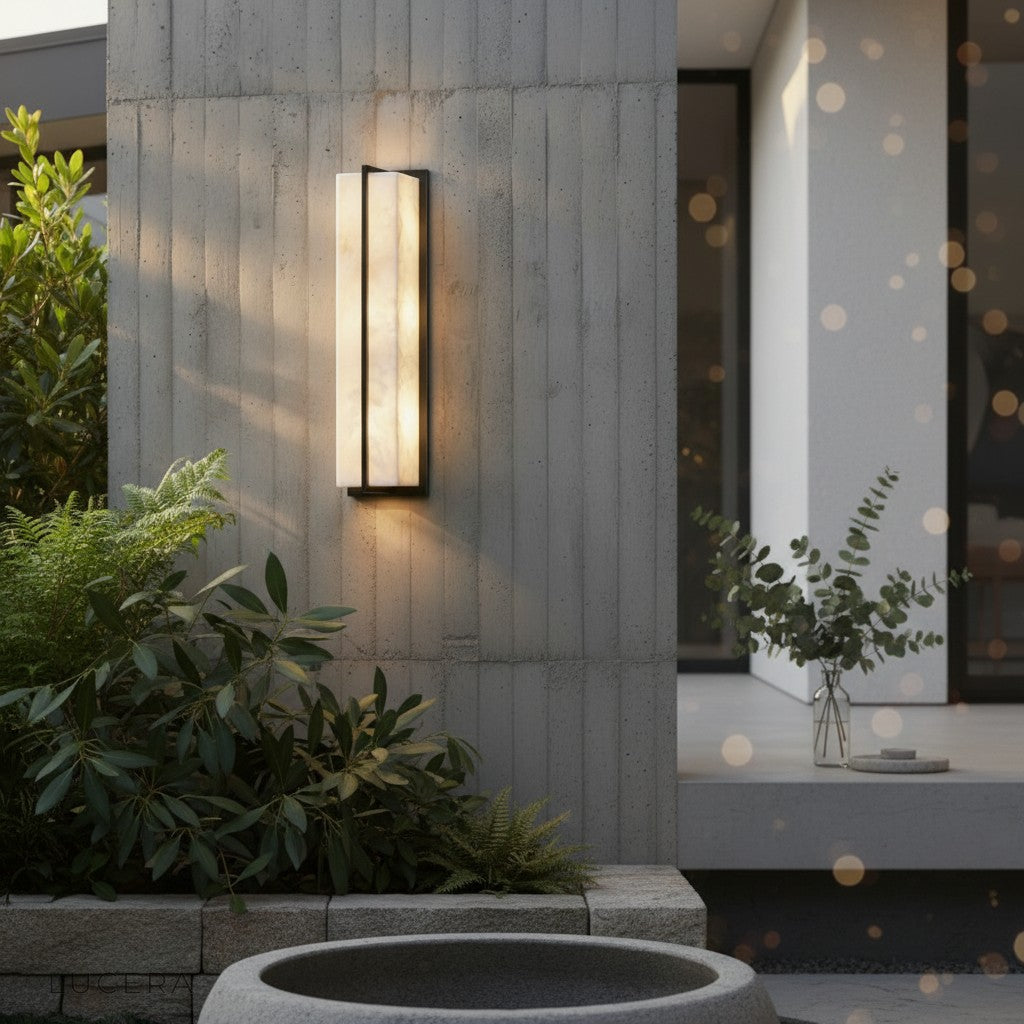 elegant garden entrance lit by the minimalist marble and copper sconce