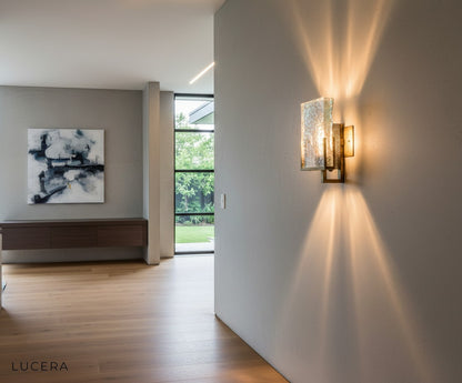 modern ice piece wall lamp in hallway with warm accent lighting against gray wall