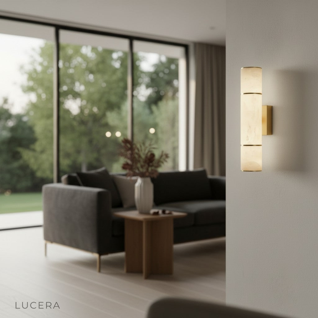 brass and marble wall sconce illuminating a dining room sideboard with elegant table setting