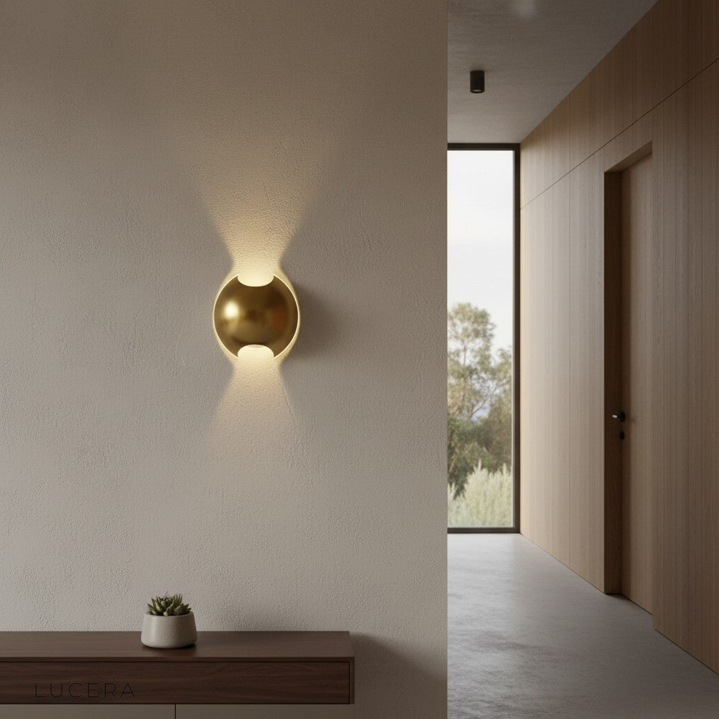 Semi sphere wall light above minimalist console table in entryway at dusk