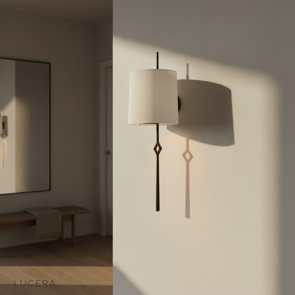 Entasis cloth wall lamp glowing warm light beside sofa in cozy bedroom