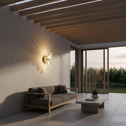 ambient shot of round crystal sconce glowing beside mirror in spa-like bathroom