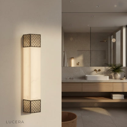 Elegant gold Astragal marble wall lamp above carved wooden console in entryway