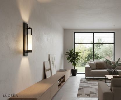 Gold finish wall light illuminating dark accent wall in contemporary bedroom