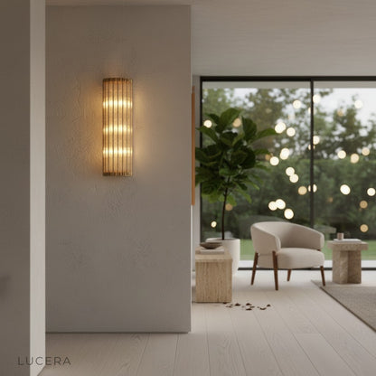 Guttae wall lamp in smaller size mounted above bedside table in cozy bedroom