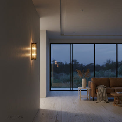 Copper and glass wall light casting layered glow in modern dining room setting