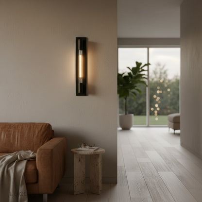Verve wall lamp casting warm glow in minimalist bedroom with linen bedding and wood accents