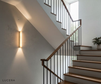 Modern marble wall light above a sleek console table in contemporary entryway