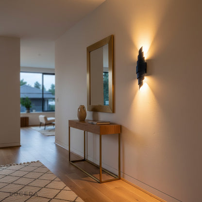 Pair of Crux Italian leather sconces flanking a headboard in a stylish bedroom at dusk with dim lamps