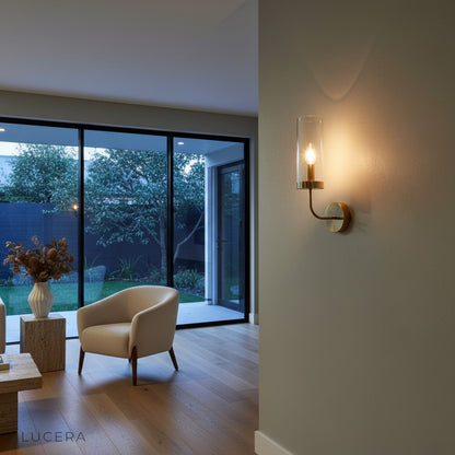 Outdoor covered patio with Medial wall lamp casting inviting light on brick wall at dusk