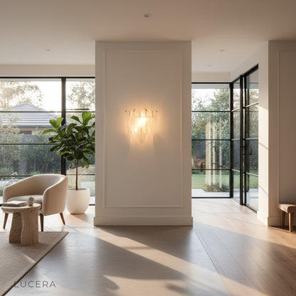 Nighttime lifestyle shot of Soli brass chandelier glowing in a serene bedroom corner