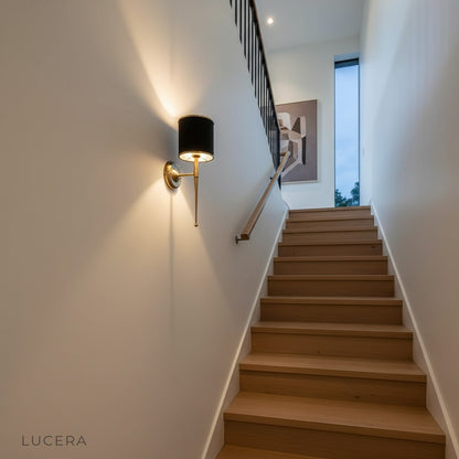 Morendo wall sconce illuminating hotel lobby wall with elegant fabric shade and metal base