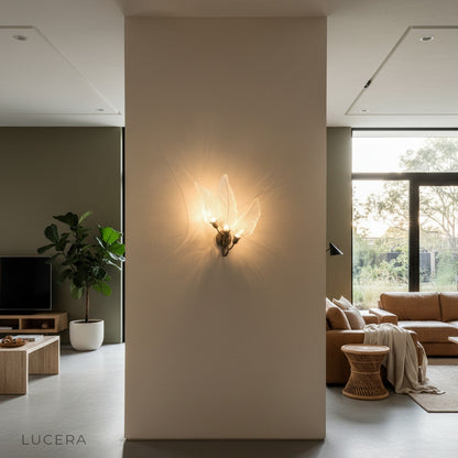 gold leaf wall lamp illuminating dark accent wall above wooden sideboard