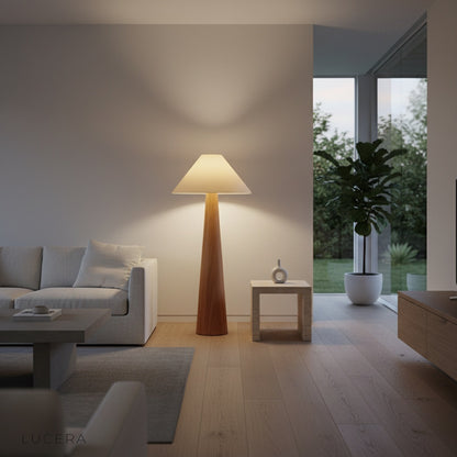 Lucera floor lamp with warm glow beside armchair in modern study room