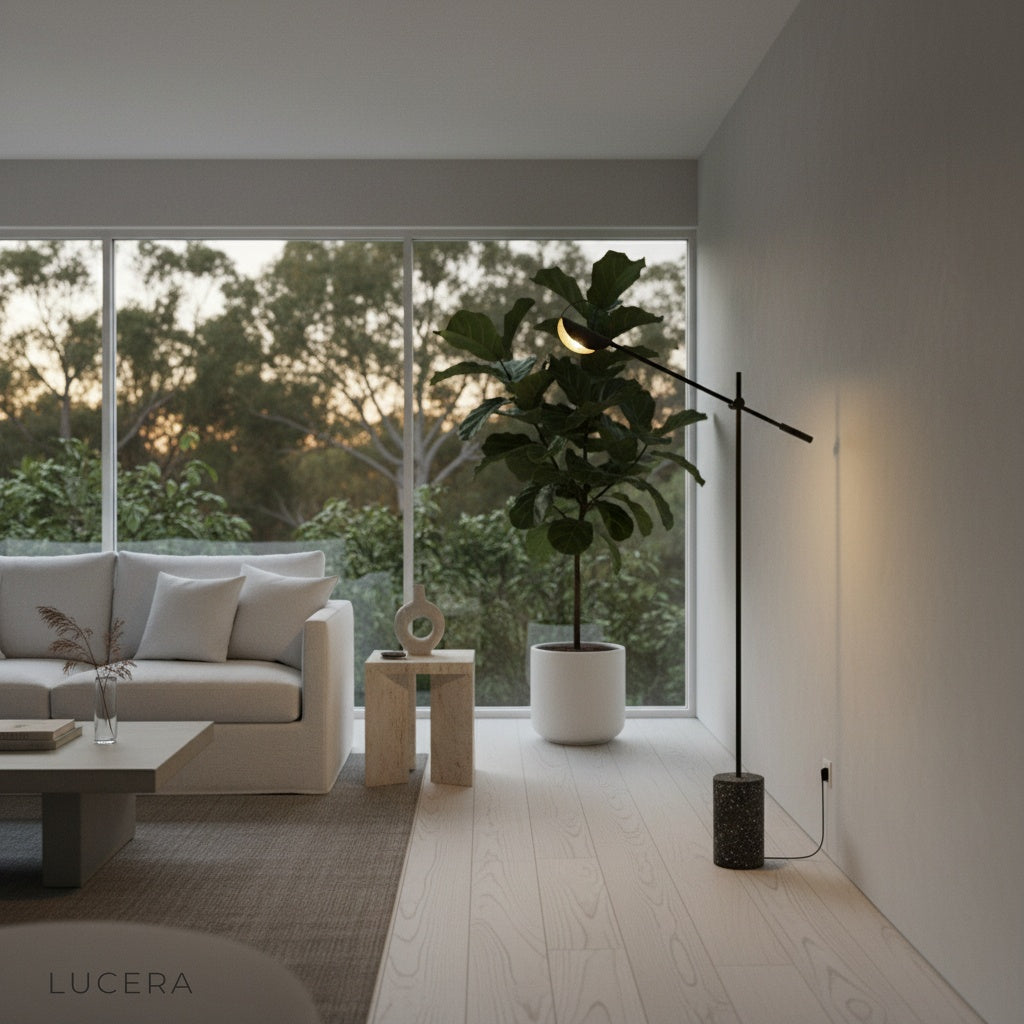 Memento Floor Lamp angled arm casting warm glow over a wooden side table in a neutral bedroom