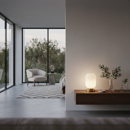 table lamp with brass base illuminating cozy armchair corner in bedroom