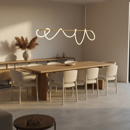 cable chandelier with twisted LED tube above cozy reading corner at night