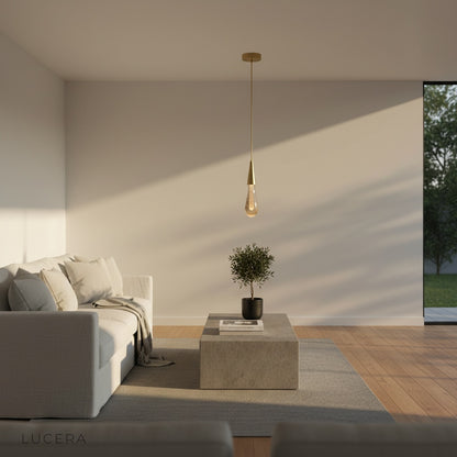 Beryl pendant light hanging above cozy reading nook with warm lamp glow
