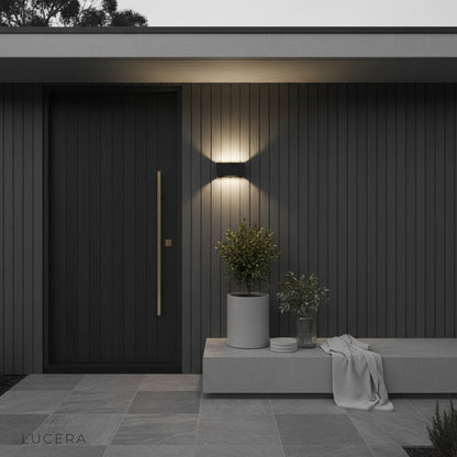 studio shot of matte black cylindrical outdoor wall sconce with two-way LED lights