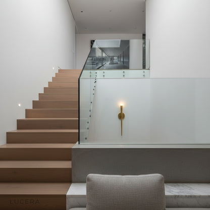 gold wall sconce casting ambient light in a cozy bedroom at night