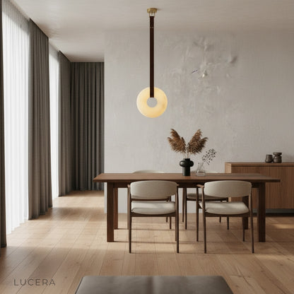 Butte Alabaster pendant light in soft daylight casting halo shadows on white wall