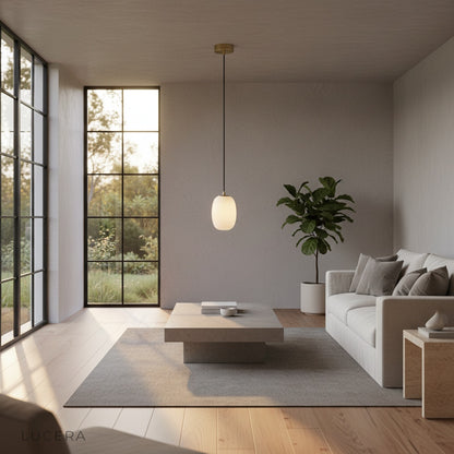Embellish Alabaster pendant light hanging over a rustic wooden dining table in soft daylight