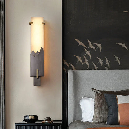 Side angle of antique marble wall lamp mounted on neutral plaster wall in bright daylight