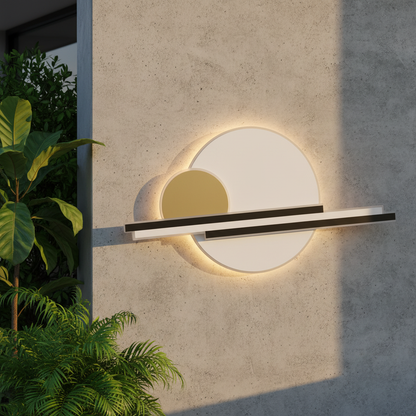 Zola black and gold outdoor LED wall lamp illuminating a modern patio wall