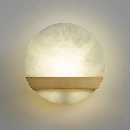 close-up of copper wall lamp arm and marble backplate showing premium material texture