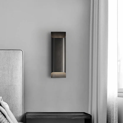 Vivace brass Nordic wall lamp illuminating minimalist living room with sofa and warm LED glow