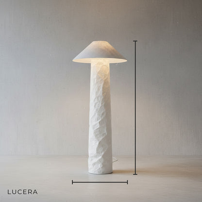 Studio view of the sculptural paper floor lamp showing its soft diffused shade and earthy base