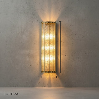 Clear glass and polished copper wall sconce studio view showing curved silhouette
