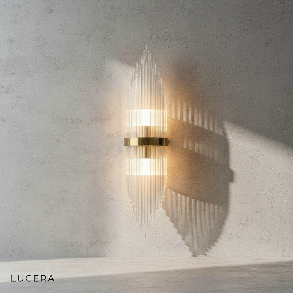 Lento gold sconce mounted above a bedside table in a cozy bedroom setting