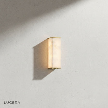 Ultime marble wall lamp angled view showing slim vertical silhouette and warm LED glow