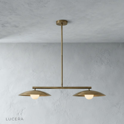Front view of the sculptural disc pendant light in a minimalist studio setting showing its linear silhouette