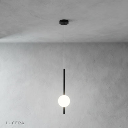 Frosted sphere pendant lamp hanging from black cord, studio product photography