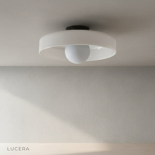 Madder ceiling light mounted on a plain wall, cylindrical silhouette with warm glow, studio lighting, side angle