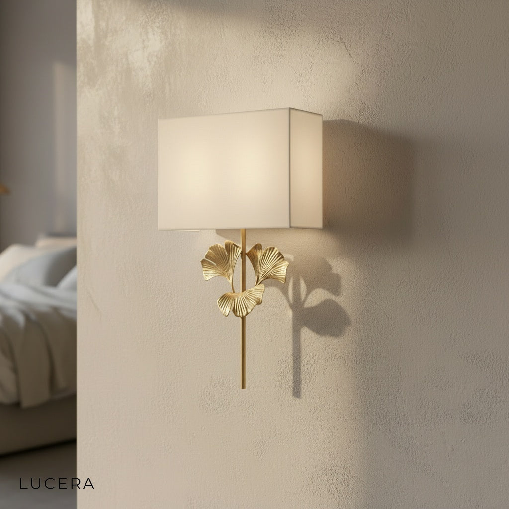studio shot of oblique brass ginkgo wall lamp with cloth shade