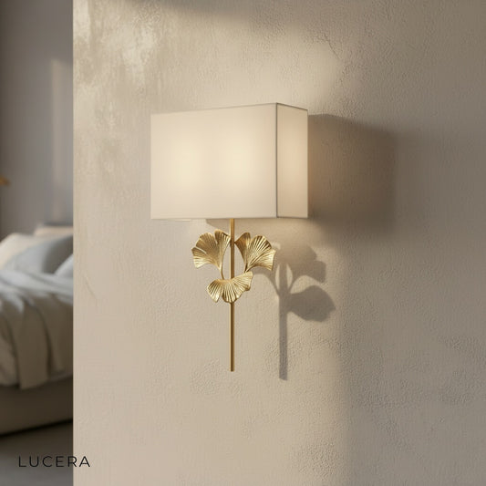 studio shot of oblique brass ginkgo wall lamp with cloth shade