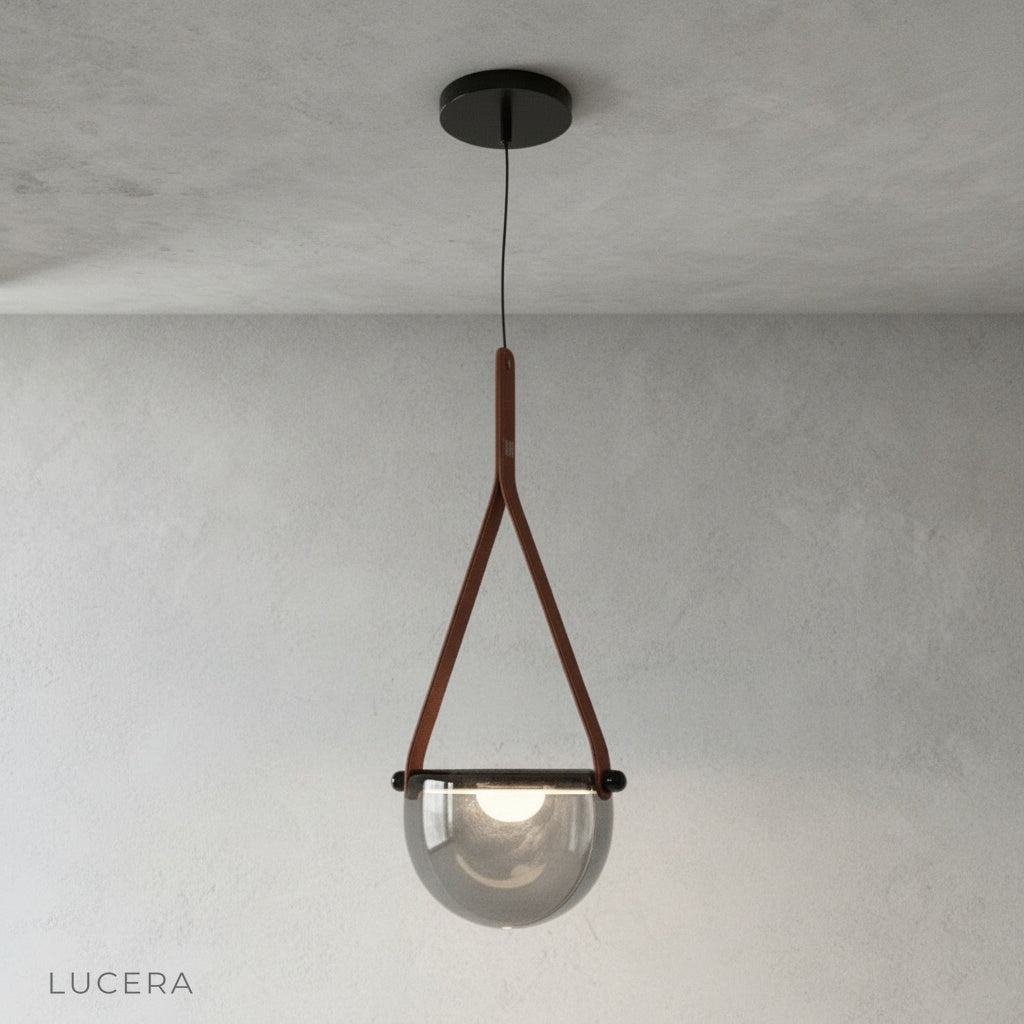 Glimmer leather strap pendant light centered on a clean white studio background